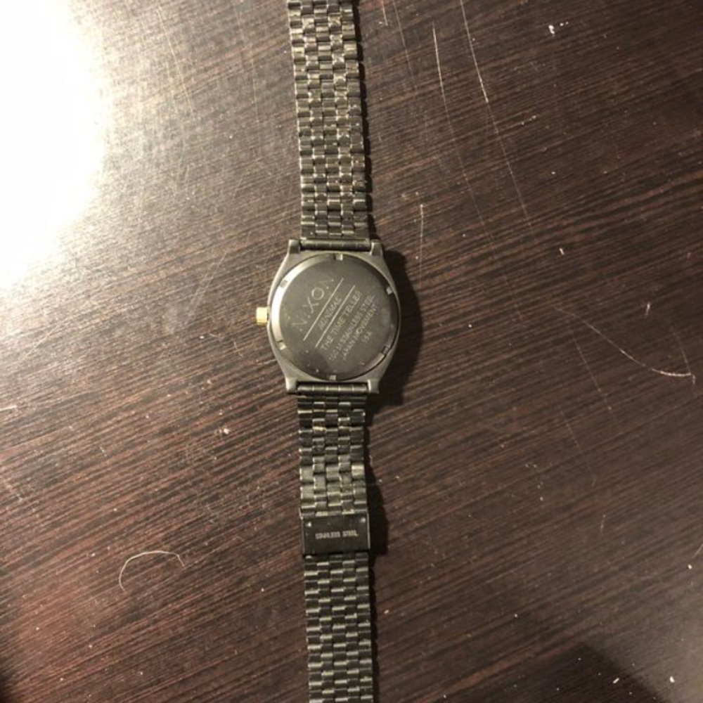 Black and gold Nixon watch